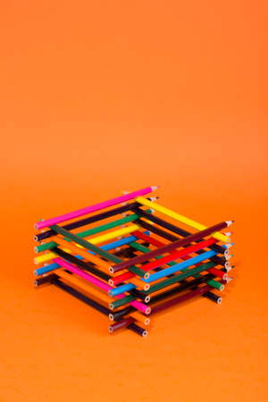 A set of colored pencils on an orange backgroundの写真素材