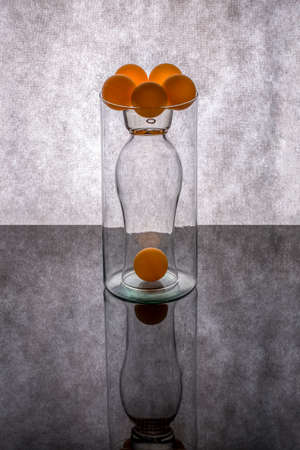 Still life with glass objects and orange ballsの写真素材