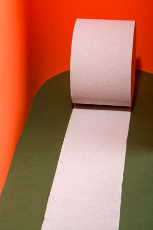 Unwound toilet paper roll on a colored backgroundの写真素材