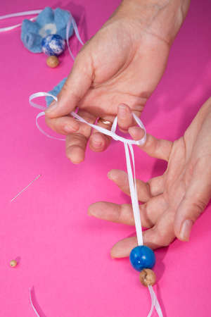 The female hands of the master assemble a handmade product from felted wool