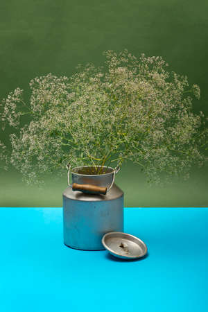 A large bouquet of wild flowers on the table in a large can