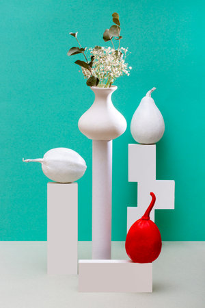 Still life with a vase of flowers, figures and a red decorative pumpkinの写真素材