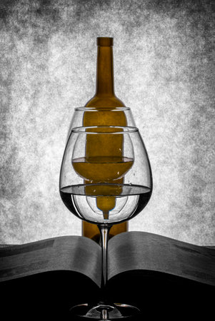 Still life with a book, an empty bottle and glasses with liquidの写真素材