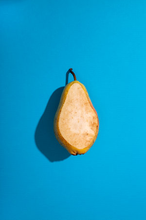 Part of a ripe pear on a blue background