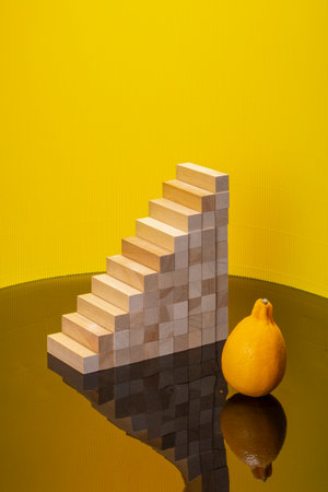 Pyramid of wooden bars and lemon with reflection