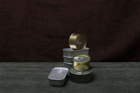 Seven iron cans of canned food on a green tableの写真素材