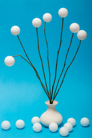Still life with a bouquet of white balls on a blue background