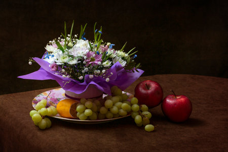 Still life with a bouquet of flowers and fruitsの写真素材