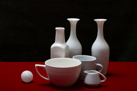 Still life with white dishes on a red tableの写真素材