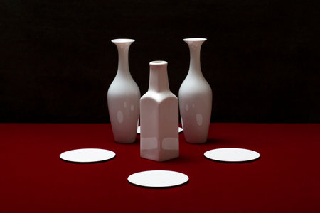 Still life with white vases on a red tableの写真素材