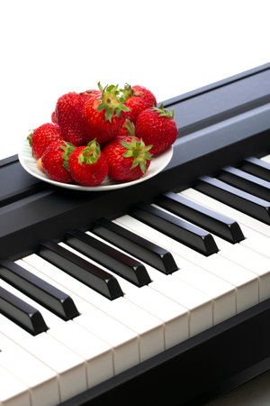 Three ripe strawberries on the piano keysの写真素材