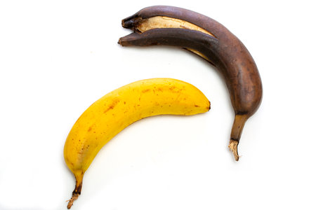 Ripe yellow and brown overripe bananas on a white backgroundの写真素材