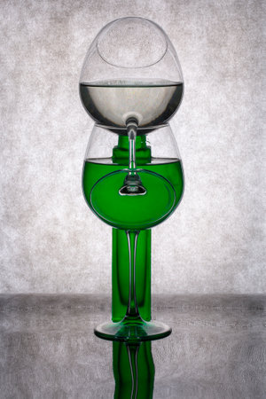 Still life with a green vase and a glass of liquidの写真素材