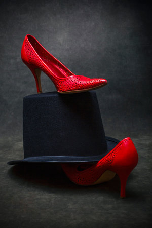 Black men's hat and women's red high-heeled shoesの写真素材