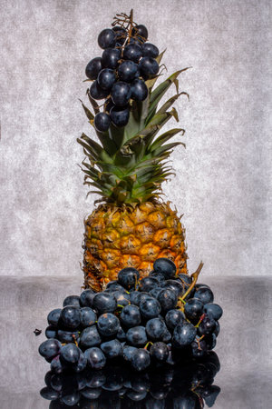 Still life with pineapple and bunches of ripe grapesの写真素材