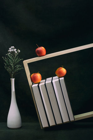 Still life with apples, books and brunia branch
