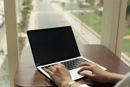 Hands typing on a laptop