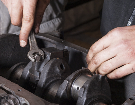 Car mechanic repairing an internal combustion engine
