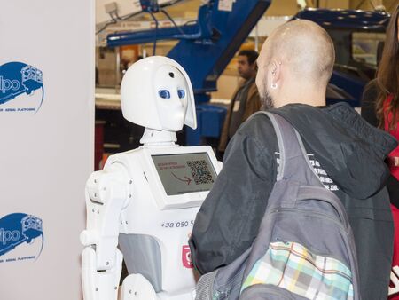 Ukraine. November 7, 2018. A man conducts a dialogue with a white robot