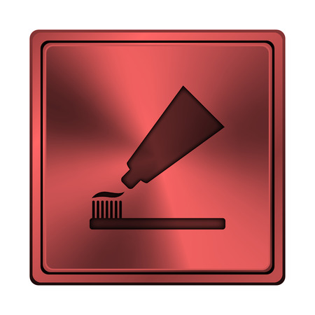 Square metallic icon with carved design on red backgroundの写真素材