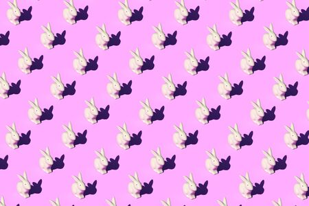 Pattern composition of Easter bunnies on pastel red background. Minimalist isometric concept.の写真素材