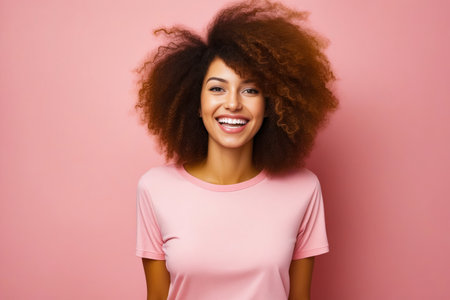 Woman with pink shirt and afro smiles at the camera. Generative AI.の素材