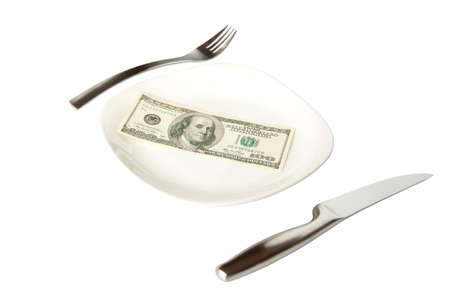 Isolated banknote on the white plate with fork and knife の写真素材