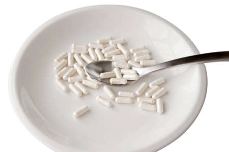 White isolated plate with pills and spoon の写真素材