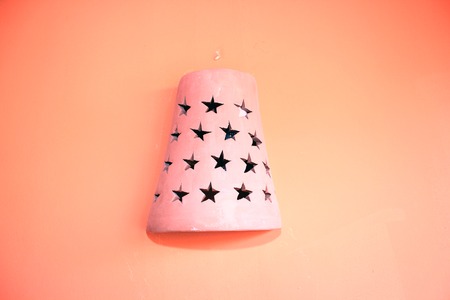 Clay old oriental lamp on orange wallの写真素材