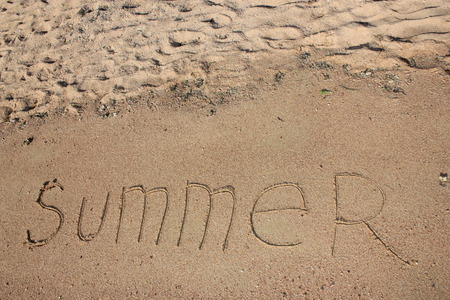 Summer text is written on wet warm sandの写真素材