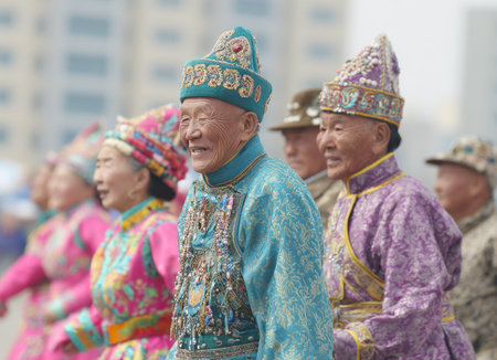 Close-up of a smiling senior man in a vibrant turquoise traditional robe and elaborately decorated hat marching in a cultural parade. He is adorned with colorful embroidery and beads, showcasing traditional ethnic clothingの素材