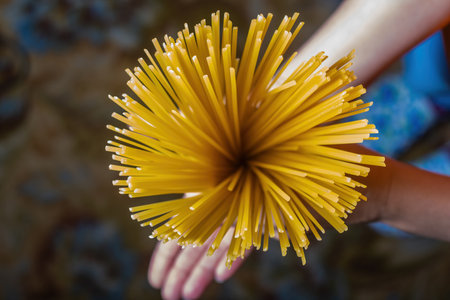 A man holding Italian raw spaghetti, ready to cook. close-upの写真素材