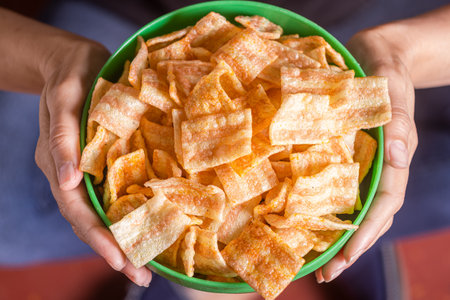 women's hands hold a plate of chipsの写真素材