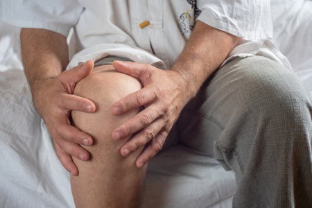 a man holds his knee, the concept of joint painの写真素材