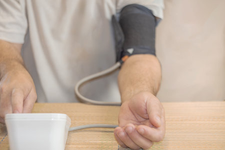 Man measuring blood pressure with a blood pressure monitor. Healthcare and medical concept.の写真素材