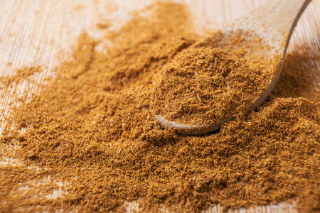 Cinnamon powder in a wooden spoon on a wooden background. Selective focus.の写真素材