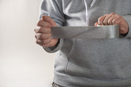 a man is holding a sticky tape on a white backgroundの写真素材