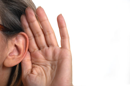 Woman covering her ears with her hand, isolated on white background.の写真素材