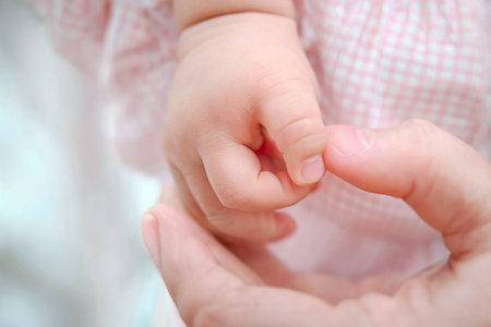 Mother holding her baby's hand, close-up, shallow depth of fieldの写真素材