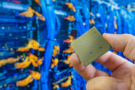 Close up of a man's hand holding a microprocessor in front of a blurred server room