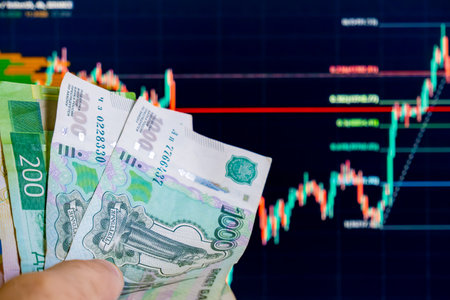 Businessman hand holding money on the background of the stock market graphの写真素材