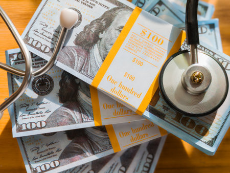 Stethoscope on a stack of 100 dollar bills, medical conceptの写真素材