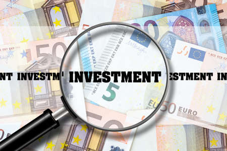 Investment, View through a magnifying glass on the inscription on the background of Euro Banknotes. Business Finance. View from above.の写真素材