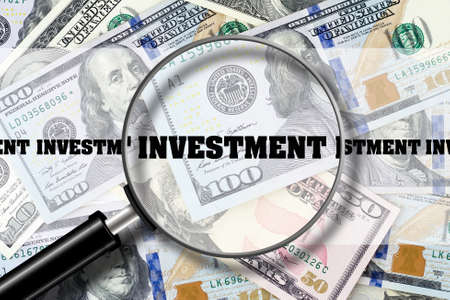 Investment, View through a magnifying glass on the inscription on the background of Dollar bills. Business Finance. View from above.の写真素材