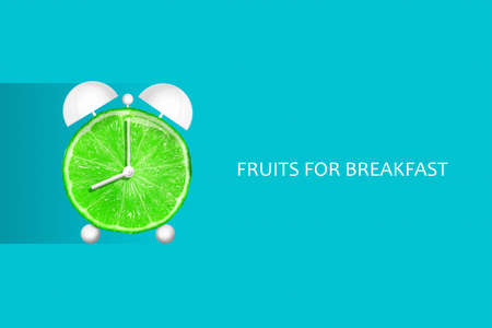 Lime in the form of an alarm clock. Fruits for breakfast. The concept of healthy eating. Diets Fresh natural fruits. Fruit background.の写真素材