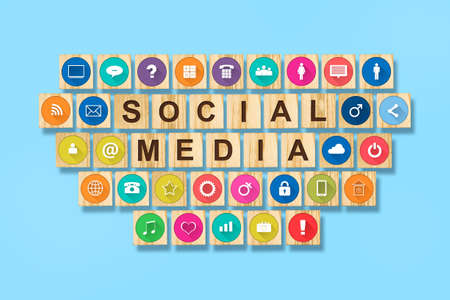 Social media concept with social icons on wooden blocks. Blue background. Communication tools.の写真素材