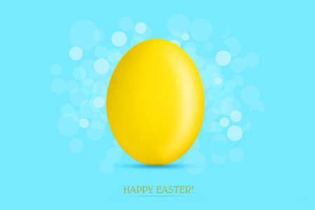 Yellow easter egg on a blue background. Easter background. Festive background.の写真素材