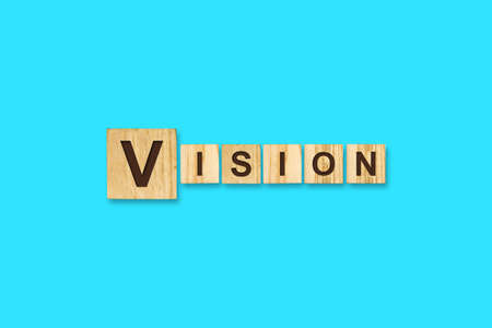 Vision. Words written on a wooden block. Blue background. Isolated. Business concept. Vision conceptの写真素材