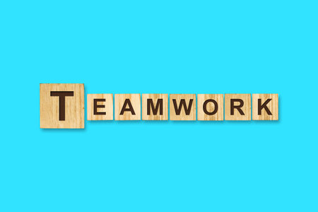 Teamwork. Words written on a wooden block. Blue background. Isolated. Business concept. Teamwork conceptの写真素材