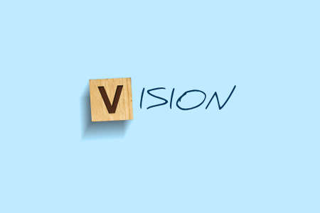 Vision. Words written on a wooden block. Blue background. Isolated. Business concept. Vision conceptの写真素材